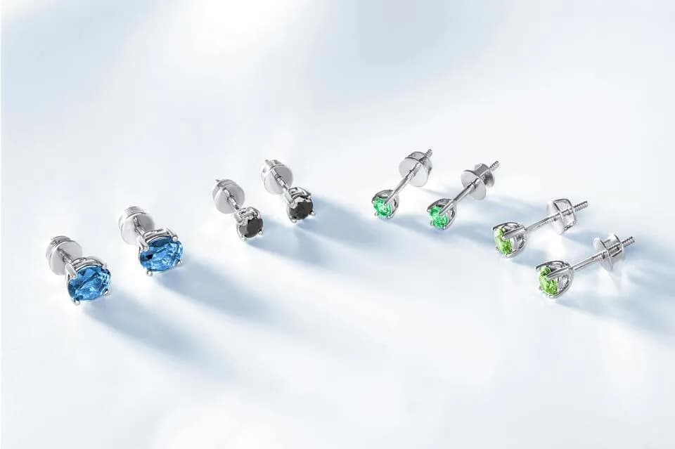 Silver gemstone stud earrings in different styles showing fine versus fashion jewelry differences.