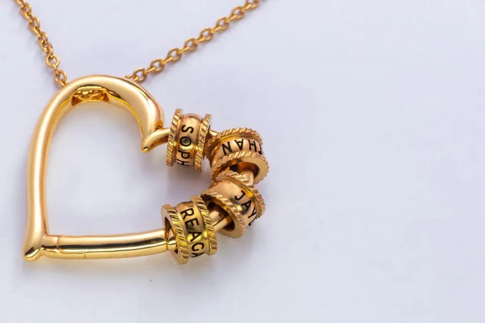 gold heart pendant necklace with engraved name beads on chain.