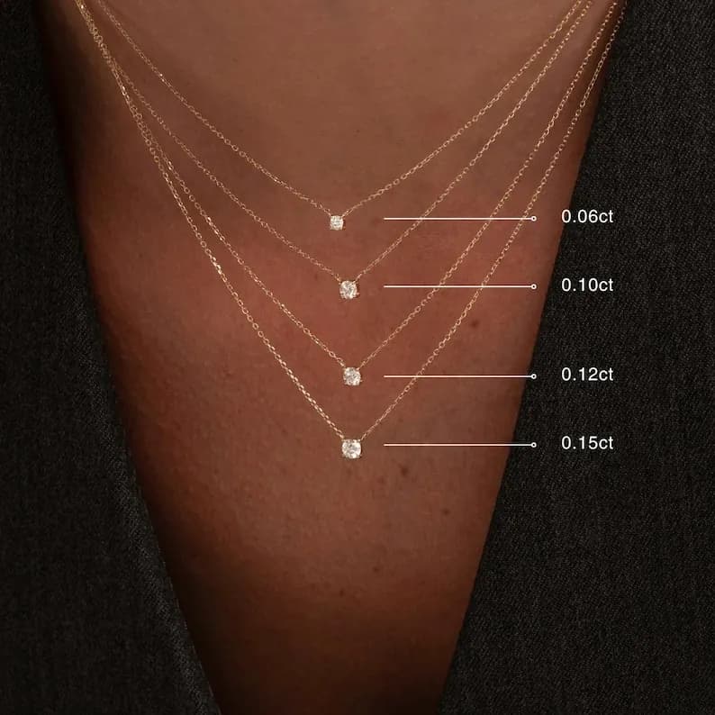 Four gold necklaces with different sized diamonds. The diamonds are 0.06ct, 0.10ct, 0.12ct, and 0.15ct.